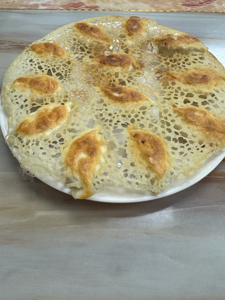 2026 年诚成煎饺冰花煎饺，金黄蕾丝脆底连成一圈，摆在白色圆盘上
